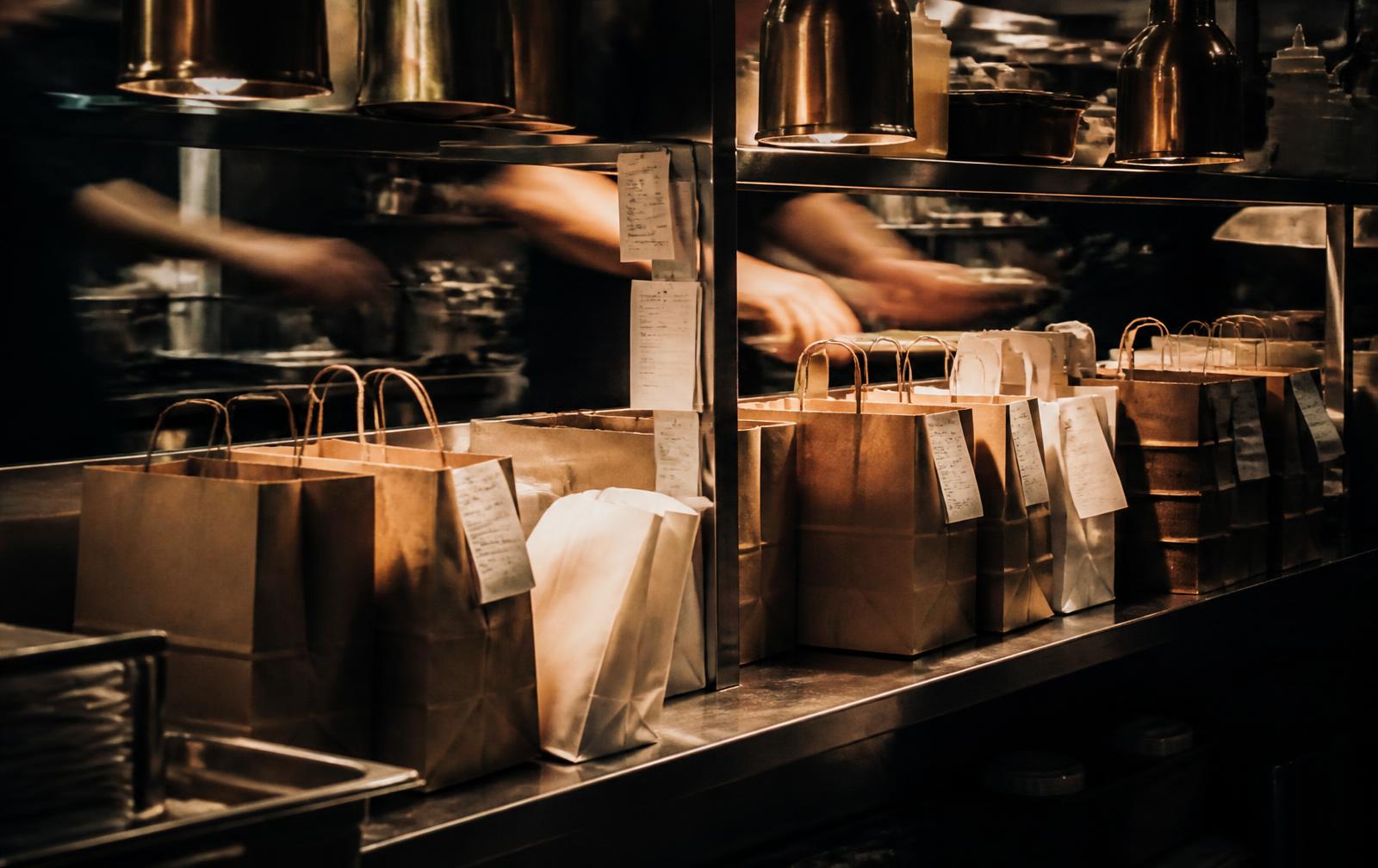 Commandes delivery prêtes au pass d'une cuisine professionnelle